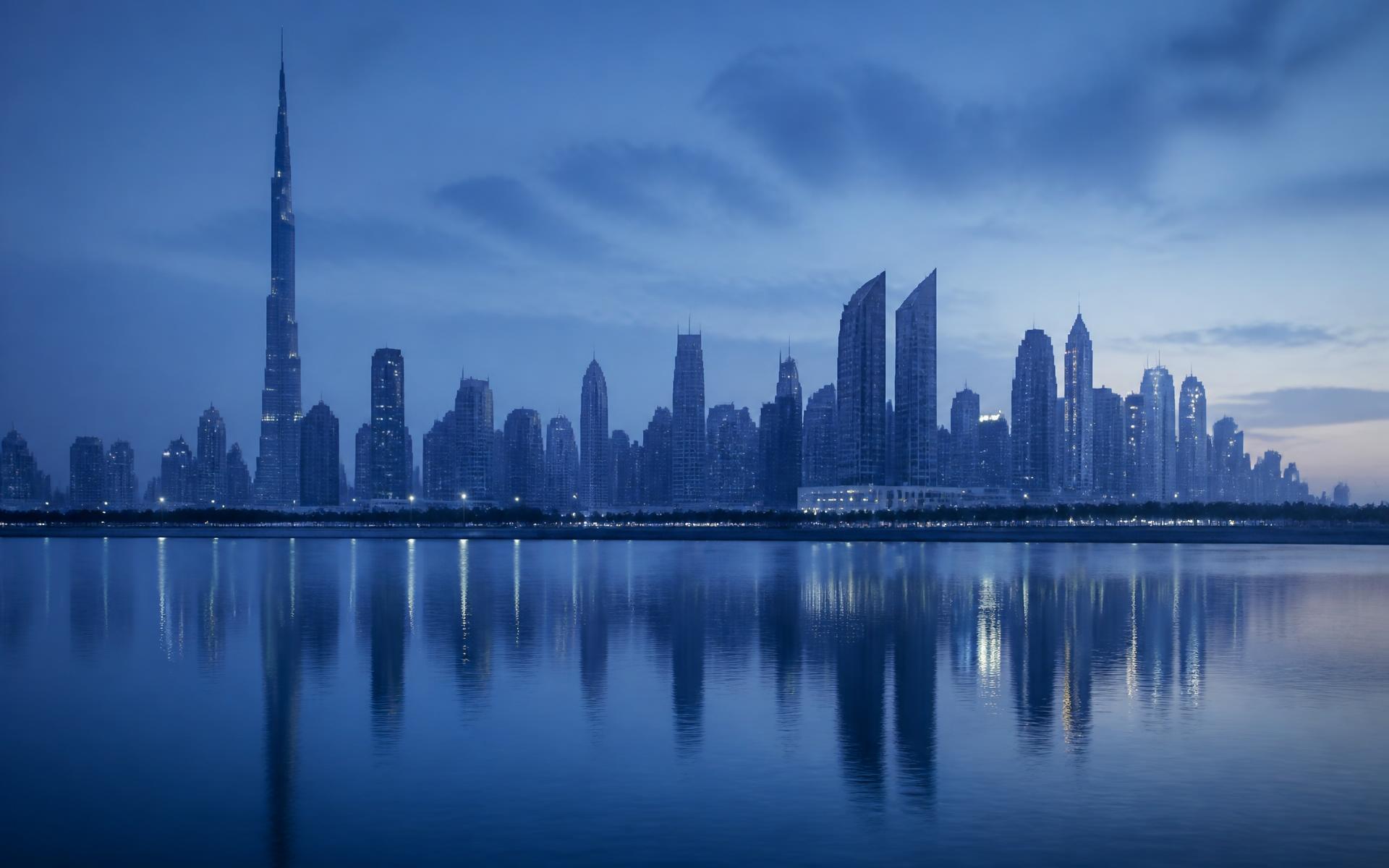 Dubai skyline at twilight reflected in calm water